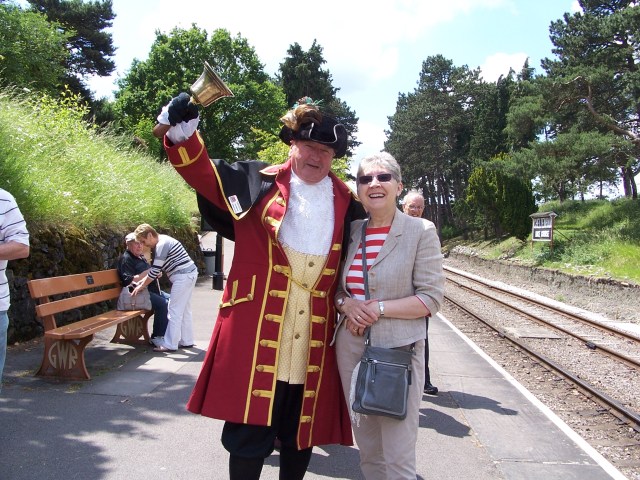 Pam with the Town Crier at Cheltenham Racecourse Station.